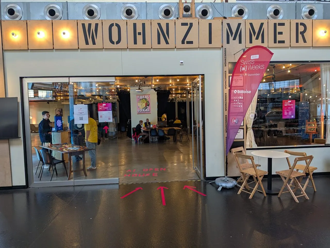 Eingang der Markthalle mit dem Schriftzug «Wohnzimmer» und einer Swiss-AI-Weeks-Beachflag